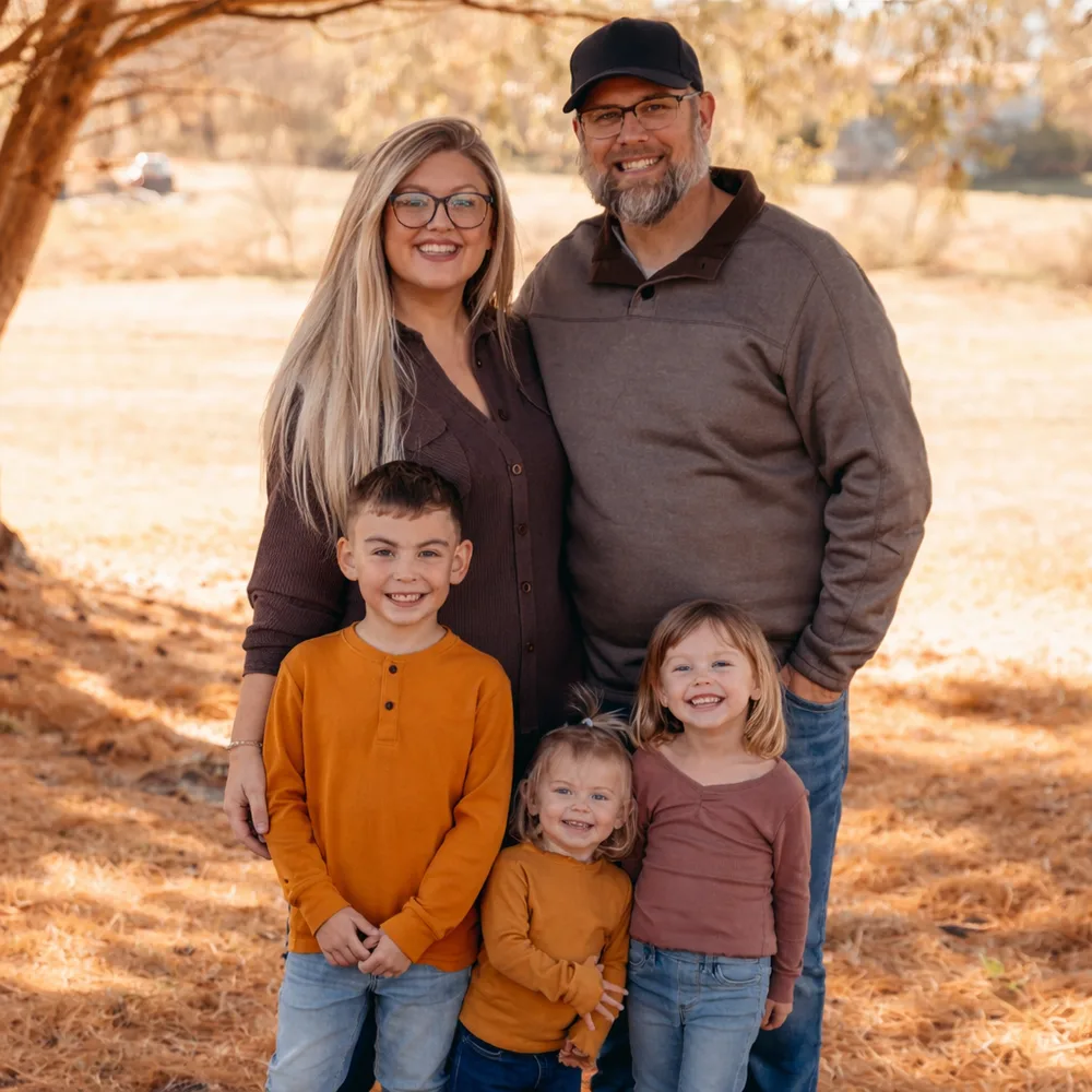 Brandon Bange with his wife Allie and their three kids — Rylann, Scarlett, and Owen — in a Missouri field